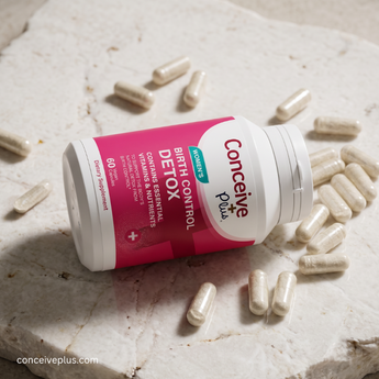 Conceive Plus birth control detox supplement bottle with capsules on a marble surface